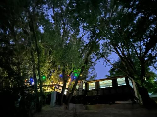 a house with a fence and trees at night at At the River Guest House in Kroonstad