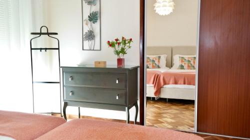 a bedroom with a bed and a dresser with a mirror at Garden Apartment, great for couple - Ponta Delgada in Ponta Delgada