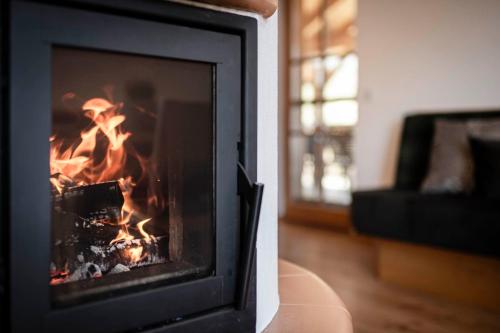 a fireplace with a fire inside of it at Großplonerhof in Luson