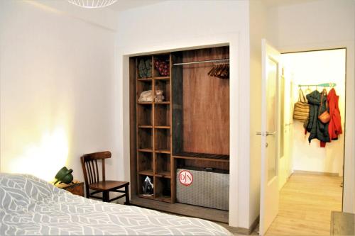 a bedroom with a closet with a bed and a chair at Cosy gezellig app met aparte gastenkamer op 30meter van strand privé garage in Koksijde
