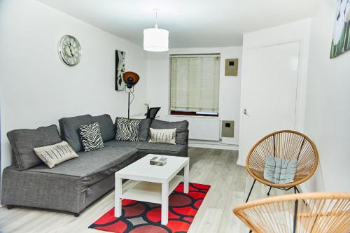 a living room with a couch and a table at Emerald Haven 5 Star Proximity in London