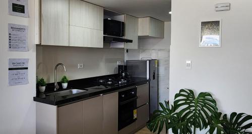 a kitchen with a sink and a refrigerator at Fantastico Apartamento Con Vista Al Atardecer in Sogamoso