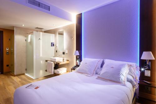 a bedroom with a large white bed with a purple wall at MB Boutique Hotel - Adults Recommended in Nerja