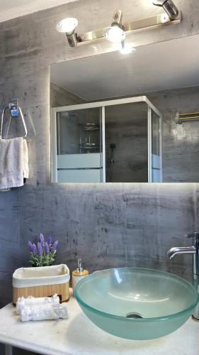 a bathroom with a glass sink and a mirror at Kampos Seaside Village in Kampos Paros