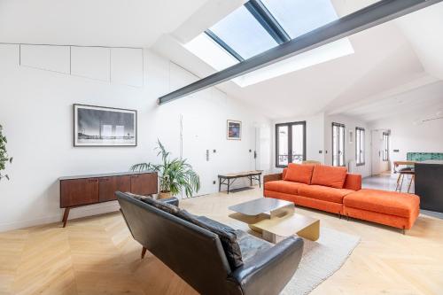 パリにあるLuxury Flat with AC "La-verrère-du-paradis"のオープンリビングルーム(ソファ、テーブル付)