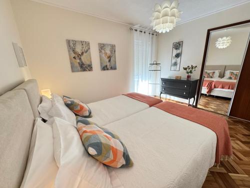 a bedroom with a white bed and a mirror at Garden Apartment, great for couple - Ponta Delgada in Ponta Delgada