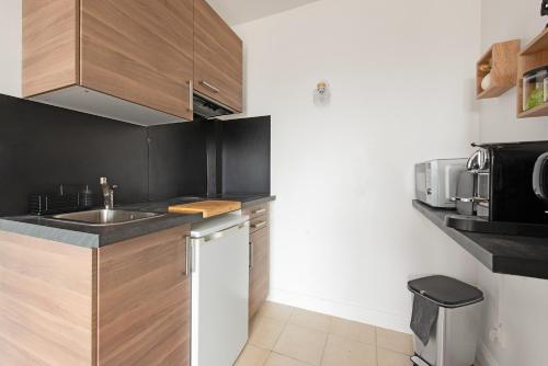 une cuisine avec un évier et un plan de travail dans l'établissement Studio sur les toits de Toulouse - proche métro, à Toulouse