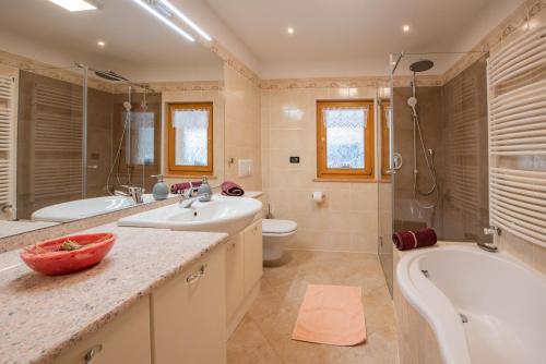 a bathroom with a sink and a tub and a toilet at Ferienwohnungen Kalchgruberhof in Ultimo