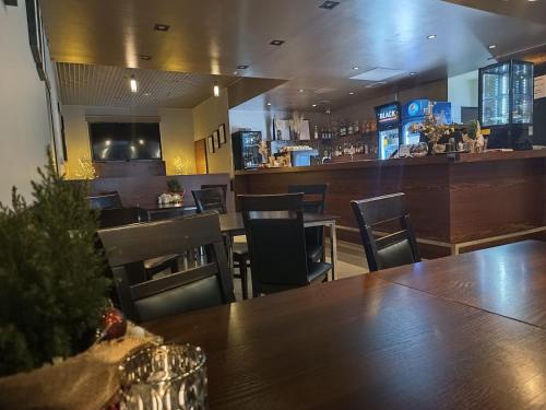 a restaurant with a table and chairs and a bar at Hotel Kolna - darmowy parking, basen w cenie in Krakow