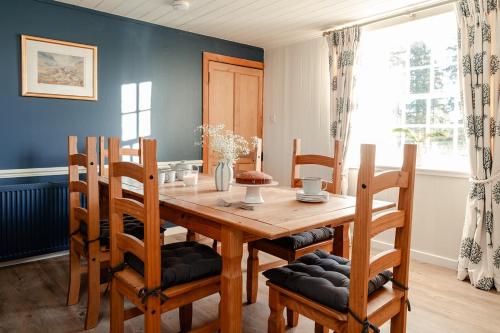 ein Esszimmer mit einem Holztisch und Stühlen in der Unterkunft Park Cottage - Seasgair Lodges in Kingussie