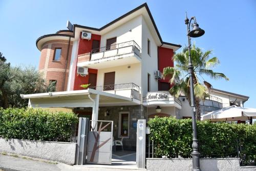 a building with a palm tree and a street light at Hotel Sirio in Rotonda