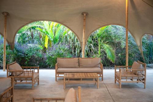 a living room with a couch and two chairs at Layla Glamping in Nir Dawid