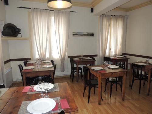 Un comedor con mesas y sillas de madera. en Fonda Can Fasersia, en La Pobla de Segur
