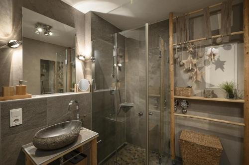 a bathroom with a sink and a glass shower at Maisonette-Apartment Das Garmisch mit Whirlpool in Garmisch-Partenkirchen