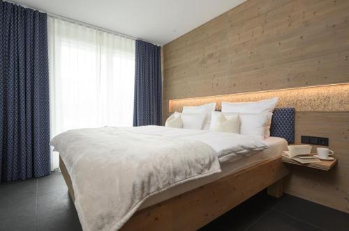 a bedroom with a large bed and a window at Maisonette-Apartment Das Garmisch mit Whirlpool in Garmisch-Partenkirchen