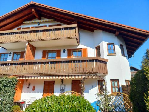a large white building with a wooden roof at Holiday apartment Sybille in Bad Kohlgrub in Bad Kohlgrub
