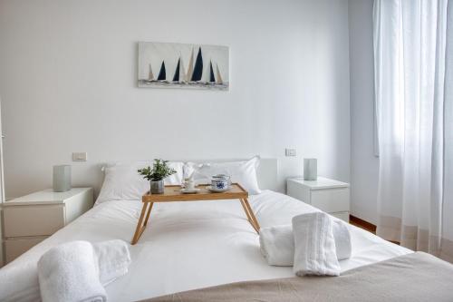 een witte slaapkamer met een bed met een tafel erop bij Easylife - Milano - Morosini 32 - Porta Romana in Milaan