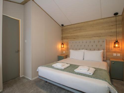a bedroom with a bed with two towels on it at Owl in Leominster