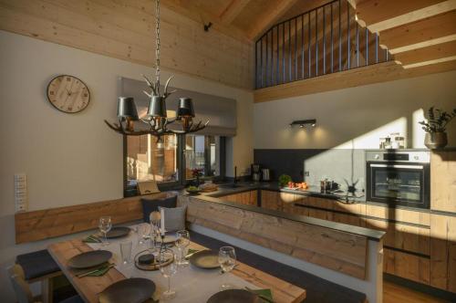 a dining room and kitchen with a table and a clock at Wetzstoa Chalet in Unterammergau mit Sauna und Whirlpool in Unterammergau