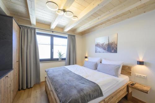 a bedroom with a large bed and a large window at Wetzstoa Chalet in Unterammergau mit Sauna und Whirlpool in Unterammergau
