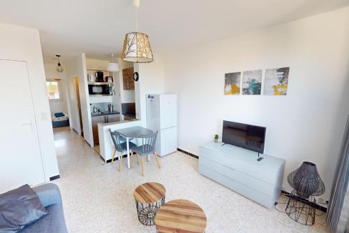 un salon avec un canapé bleu et une table dans l'établissement Appartement T2 vue plage Mèze proche Sète, à Mèze