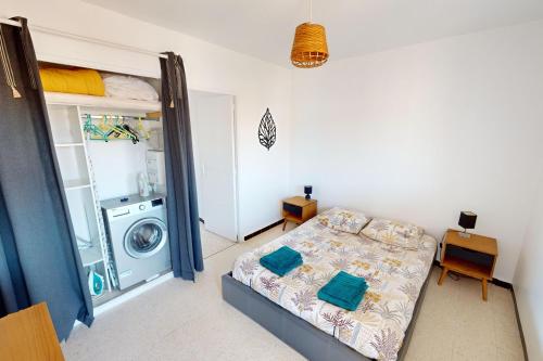 - une chambre avec un lit et un lave-linge dans l'établissement Appartement T2 vue plage Mèze proche Sète, à Mèze