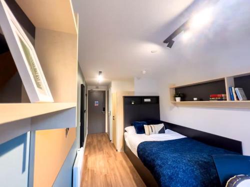 a small room with two beds and a book shelf at Ensuites in Portsburgh Court Edinburgh in Edinburgh