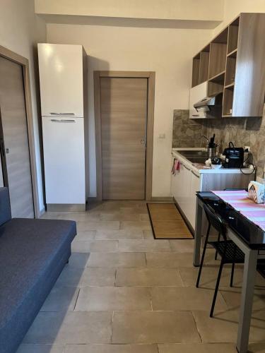 a kitchen with a table and a white refrigerator at Mambo House in Milan