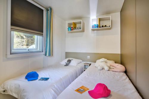 une chambre avec deux lits avec des animaux rembourrés dans l'établissement Domaine Résidentiel de Plein Air Les Paludiers, à Batz-sur-Mer