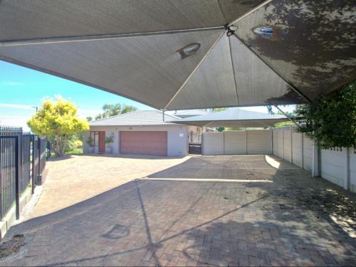 a large white umbrella in front of a house at Glennies Guesthouse in Somerset West