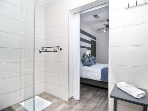 a bathroom with a shower and a bed at Glennies Guesthouse in Somerset West