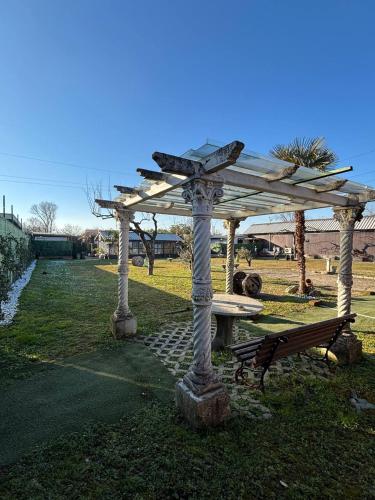 a wooden pergola with a picnic table and a bench at Mambo House in Milan