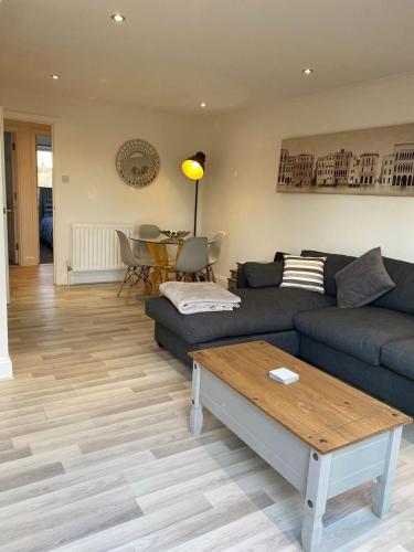 a living room with a couch and a table at Penthouse Waterfront Apartment - St Neots in Saint Neots