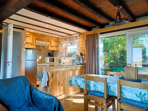 a kitchen and dining room with a table and chairs at Louloudia Bonsoy Jaune 12 huis in het bos met mooi uitzicht en kalmte in Blaimont