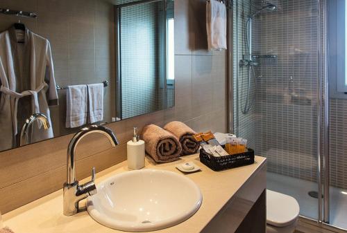 La salle de bains est pourvue d'un lavabo, de toilettes et d'une douche. dans l'établissement Apartaments Maritim, à Castelldefels