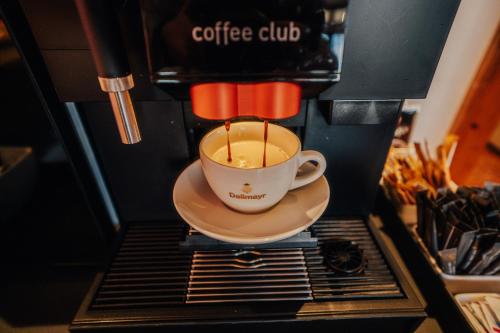 a coffee cup is being brewed in a coffeeoke at Lechpark Hotel in Untermeitingen
