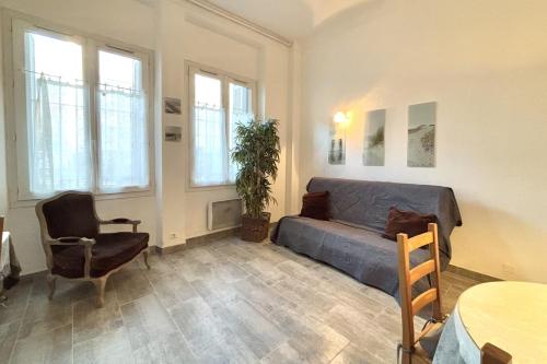 - un salon avec un canapé, une table et des fenêtres dans l'établissement Luminous T2 on the seafront, à Cannes