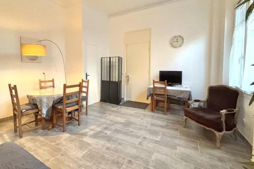 un salon avec une table, des chaises et une télévision dans l'établissement Luminous T2 on the seafront, à Cannes