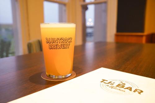 a glass of beer sitting on top of a table at Tommy Jacks Beach Apartments in Bude