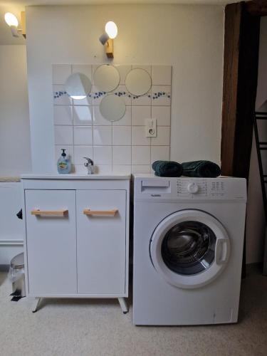 - une buanderie avec un lave-linge et un évier dans l'établissement Appartement atypique au cœur de Gray, à Gray