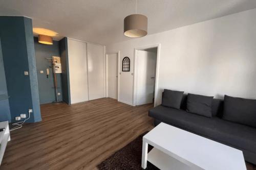 a living room with a couch and a table at Soh Rent Appartement strasbourg Neudorf ménagerie TV - Wifi in Strasbourg
