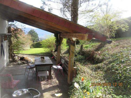 a wooden pergola with a table in a garden at Salzkammergut, a place to enjoy in Traunkirchen