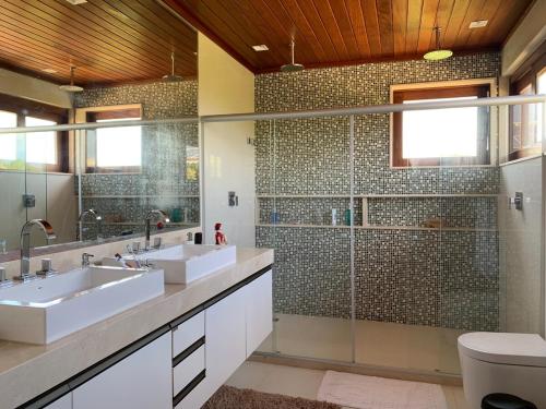 un bagno con due lavandini e una doccia di Casa do Sol - Praia do Forte a Mata de Sao Joao