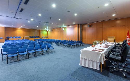 a conference room with tables and blue chairs at El Mouradi Hotel Africa Tunis in Tunis