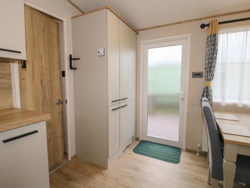 a kitchen with a desk and a table and a door at Heron in Leominster