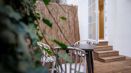 a table and chairs on a porch with a fence at CLOUD 5 Blloku Rooms Tirana in Tirana