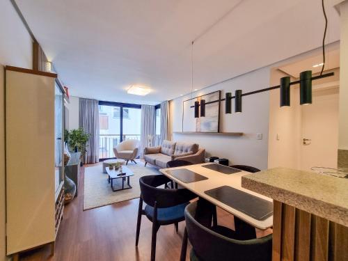 a kitchen and living room with a table and chairs at Apartamento Luxo, no Centro de Canela in Canela