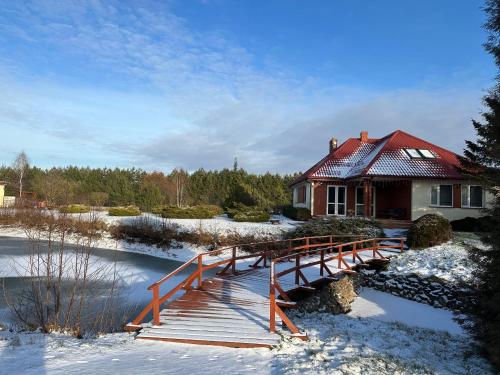 a bridge over a river in front of a house at Willa u Bociana in Siemianówka