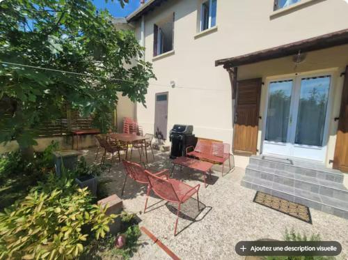 a patio with chairs and a grill in front of a house at Charmant appartement 35 m2 avec terrasse et jardin in Domont