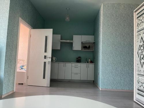 eine Küche mit weißen Schränken und einer grünen Wand in der Unterkunft Видовые апартаменты рядом клиника Рахманова in Dnipro